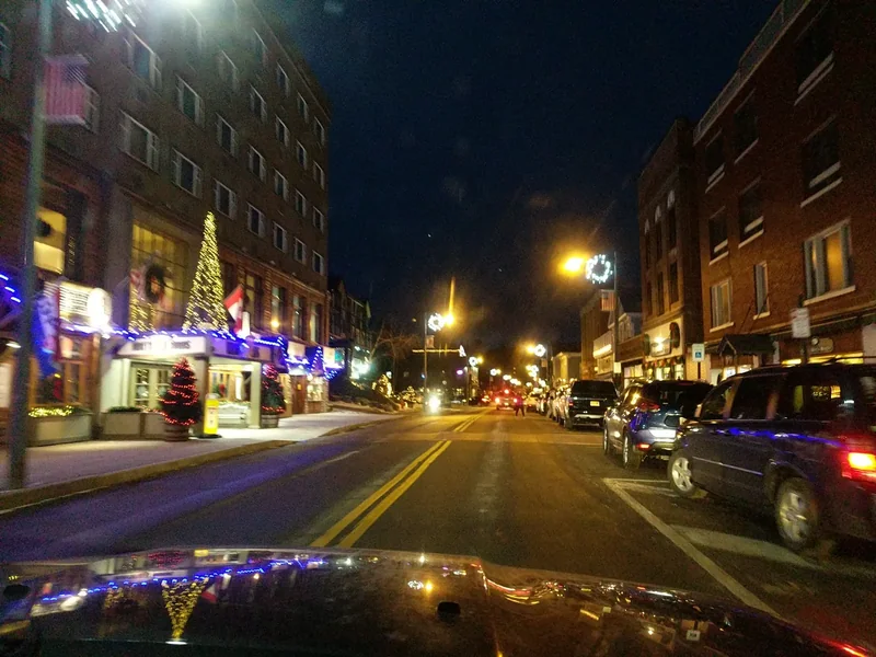 Main Street in Lake Placid on a winter night, with holiday lights on the shopfronts
