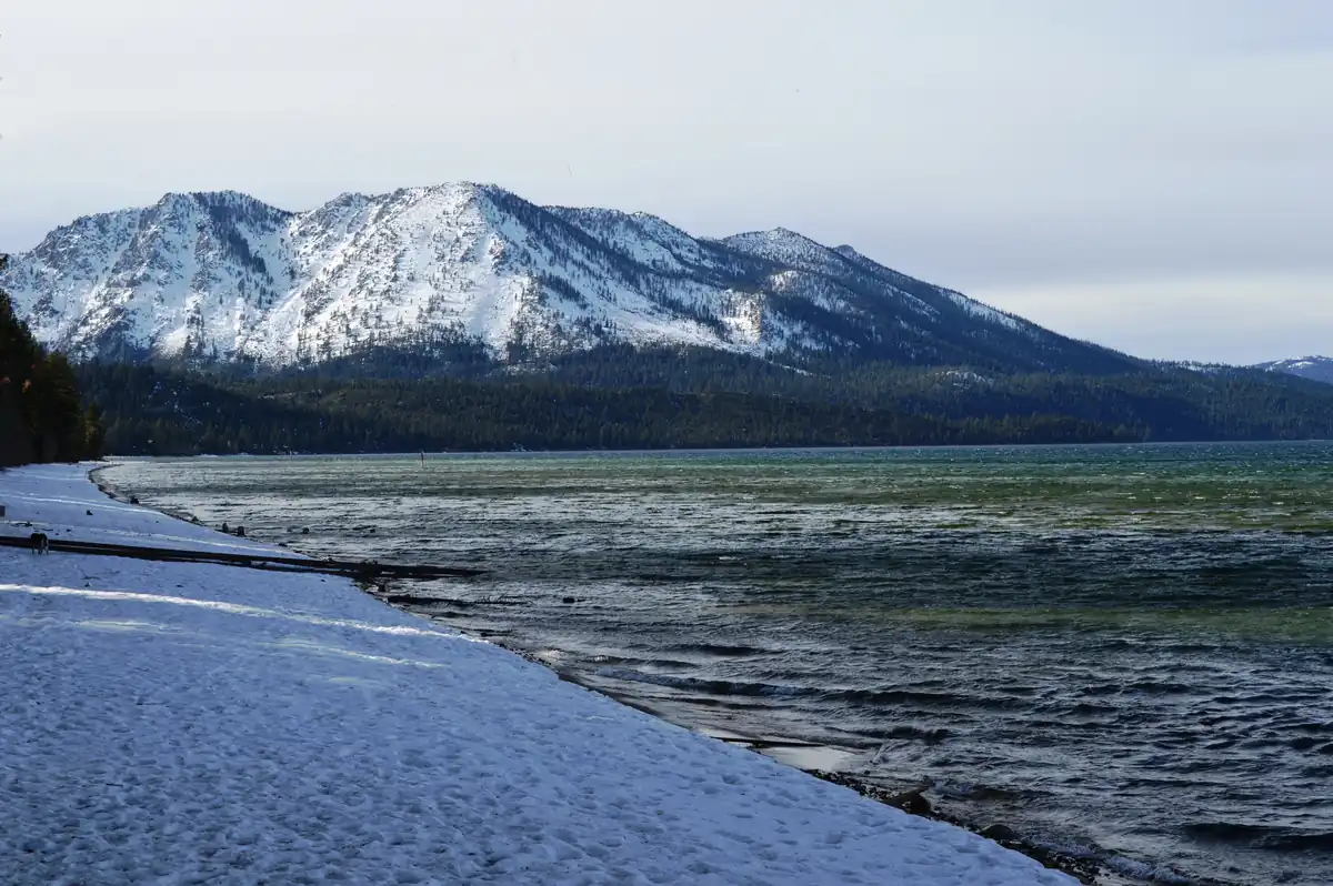 Sand Harbor shoreline in winter with crystal water and snowy pines