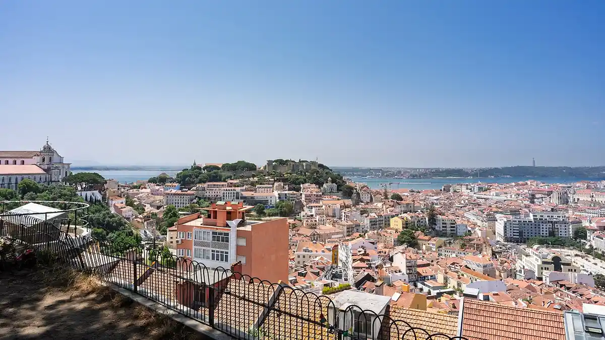Lisbon from the Miradouro da Senhora do Monte — Alfama rooftops and the Tagus at dusk