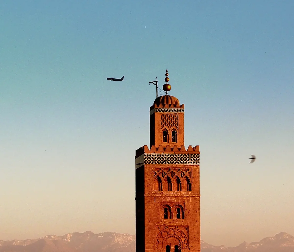 The Koutoubia minaret over Marrakech with the snowy High Atlas behind