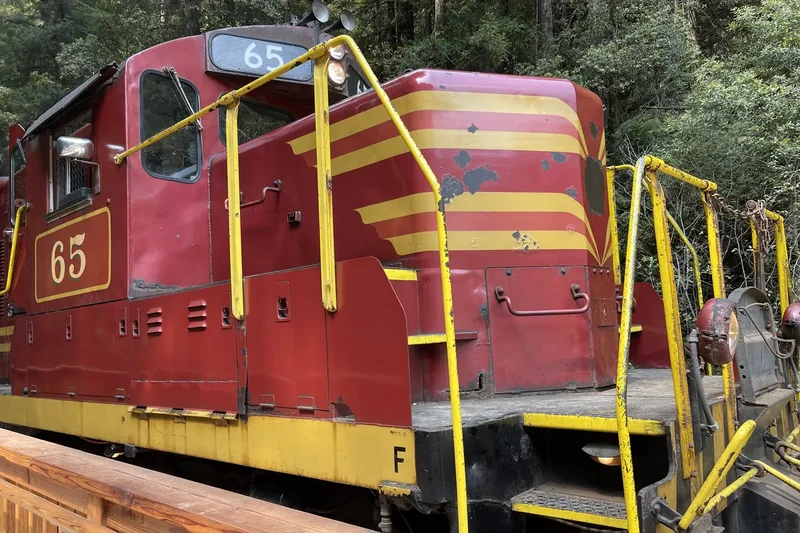 A red and yellow Skunk Train locomotive, engine 65, at the station in Fort Bragg