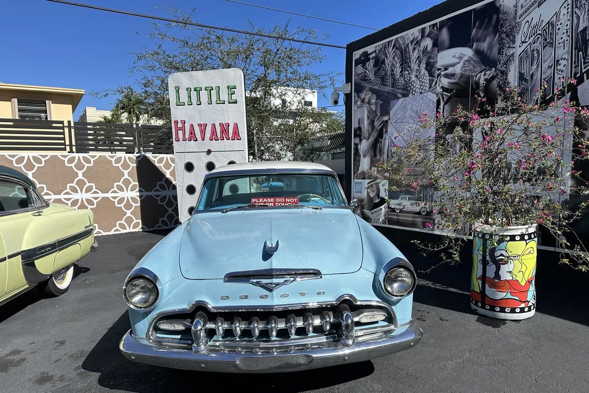 A classic car parked by a mural on Calle Ocho in Little Havana