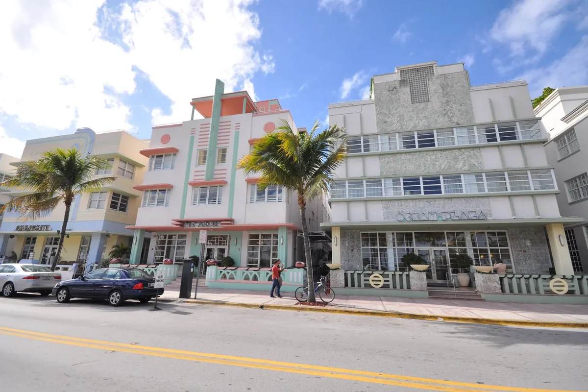 Pastel Art Deco hotels with palm trees along Ocean Drive in Miami Beach under a blue sky