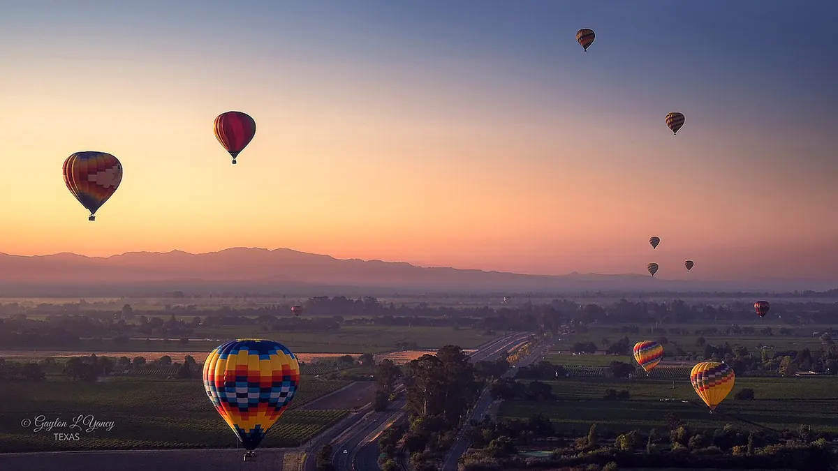 Hot-air balloons aloft above the valley at sunrise