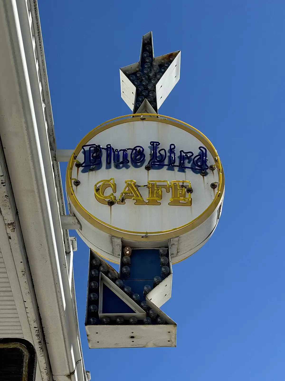 The Bluebird Cafe's rooftop sign against a blue sky