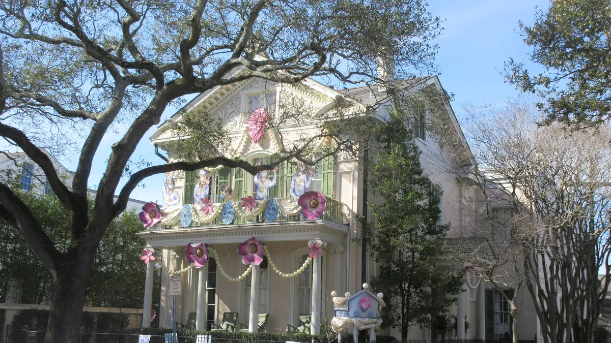 A house on St. Charles Avenue in New Orleans decorated for Mardi Gras in purple, green and gold