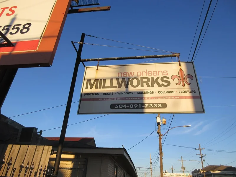 Vintage signs above a shop on Magazine Street uptown in New Orleans under a blue sky