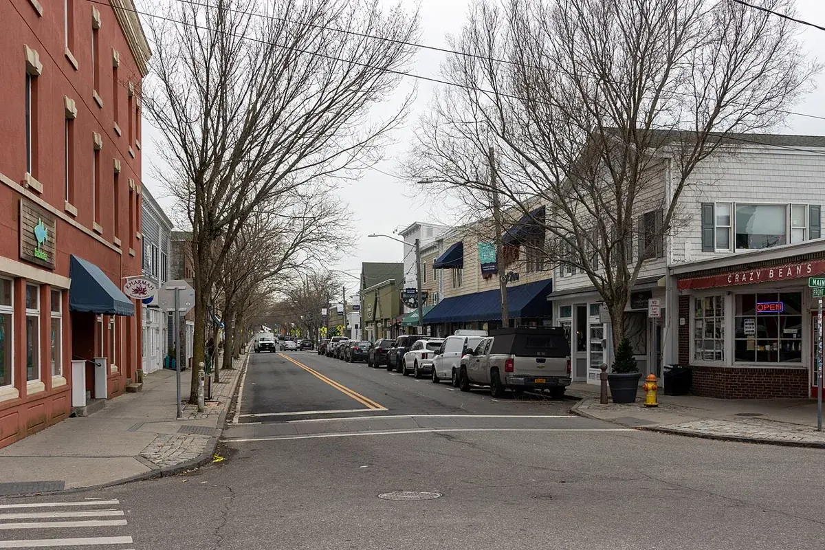 Front Street in Greenport, low brick and clapboard shopfronts and bare trees along a quiet street