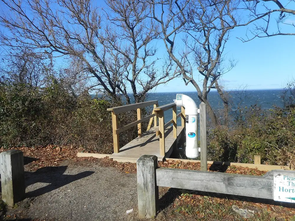 A wooden fence on the bluff at Horton Point in Southold, with bare trees and Long Island Sound beyond