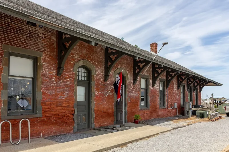 The red-brick Greenport railroad station with arched windows and a wooden canopy