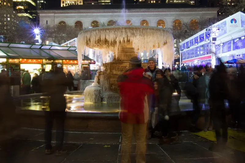 The frozen Josephine Shaw Lowell Memorial Fountain in Bryant Park with people taking pictures