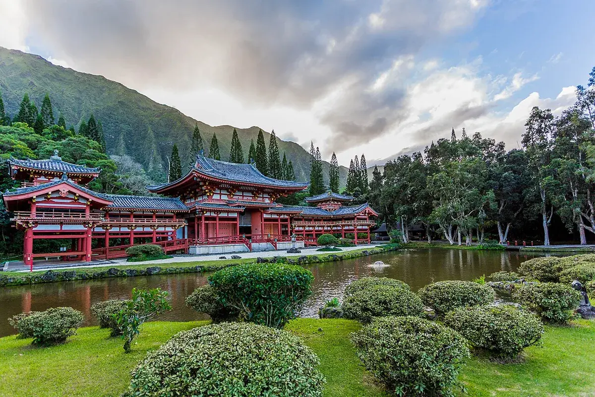 The red Byodo-In Temple beside its pond, with the green Koʻolau mountains behind