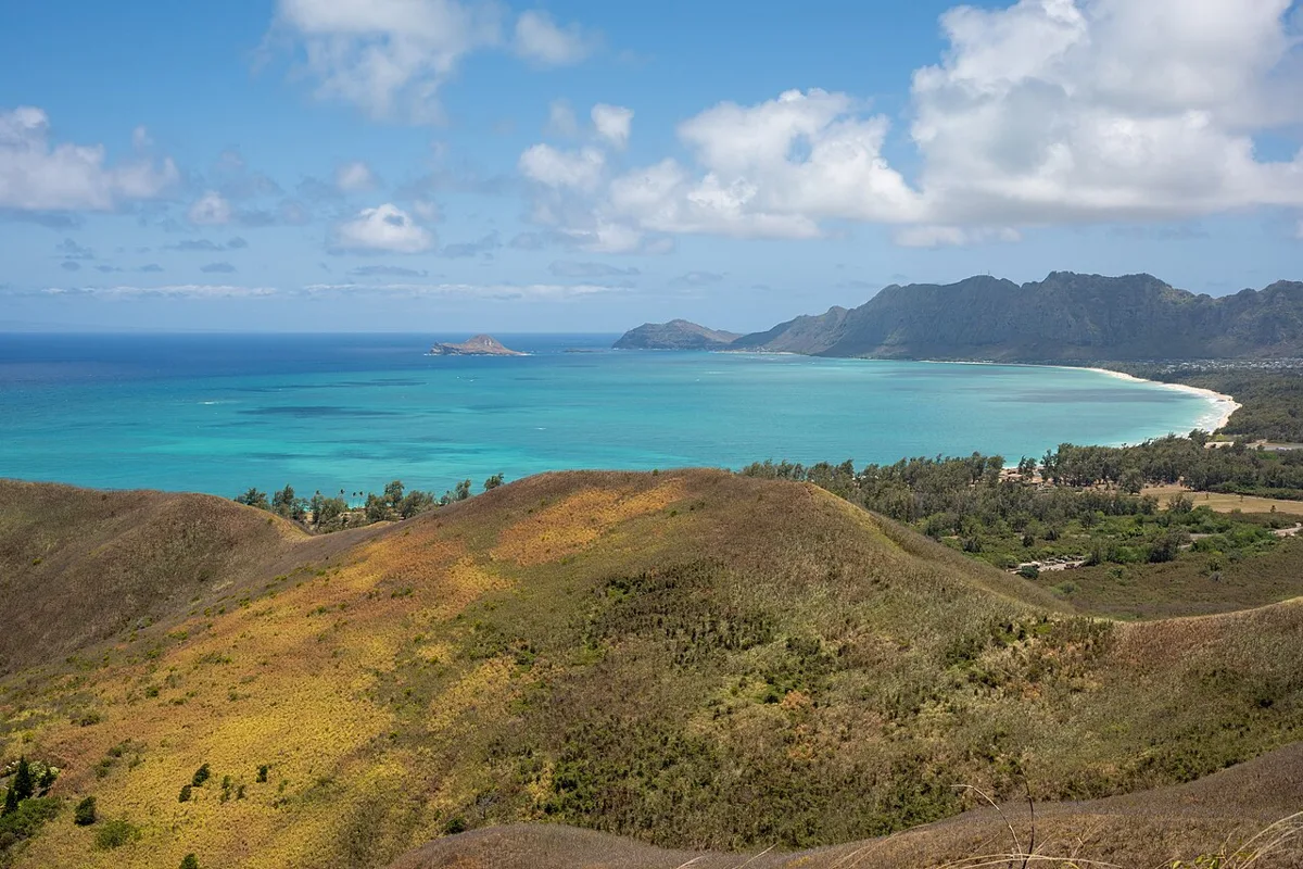 The view from the Lanikai Pillbox trail over grassy slopes to the turquoise sea and the windward coast