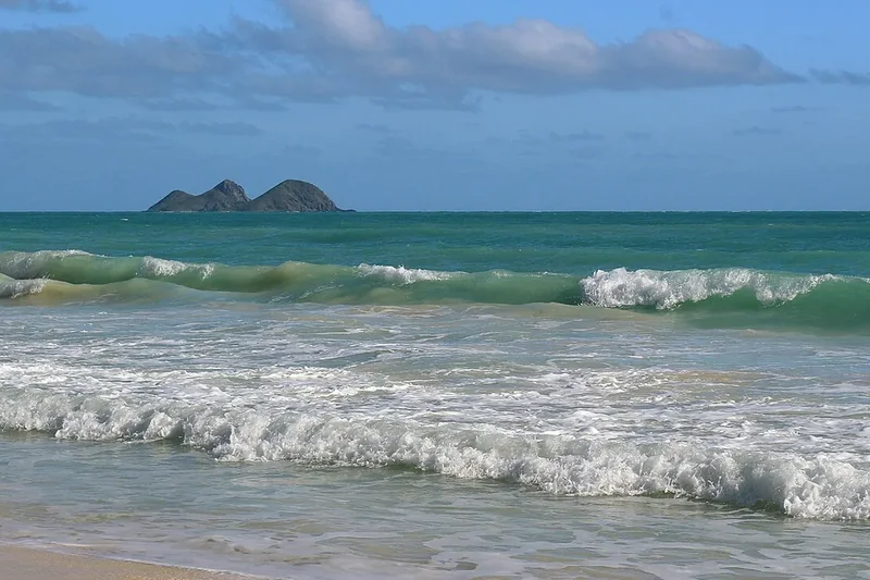 The Mokulua islets seen across deep blue water from the windward coast of Oahu