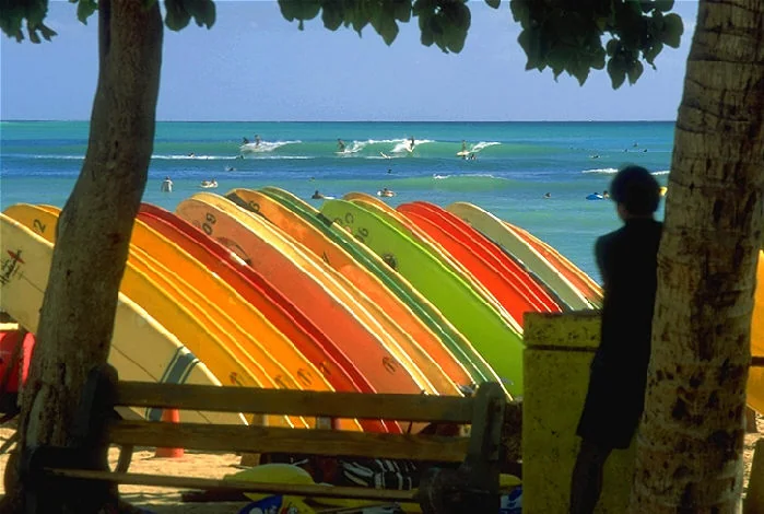Surfboards on Waikiki Beach with surfers in the waves
