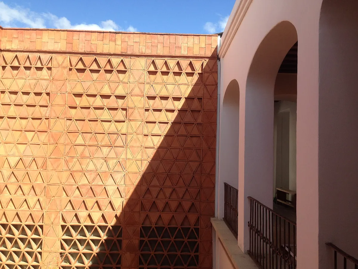 The brick lattice and stone arches of the Museo Textil de Oaxaca courtyard