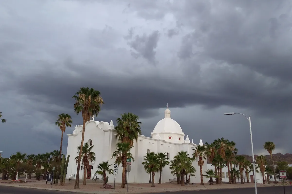 The white Immaculate Conception Church in Ajo with its bell tower against a blue sky
