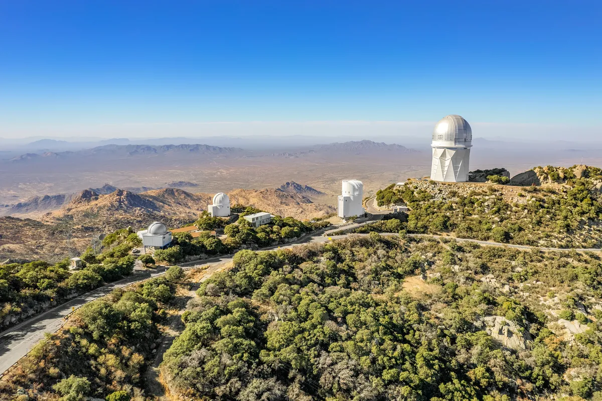 White telescope domes on the summit of Kitt Peak against a clear sky