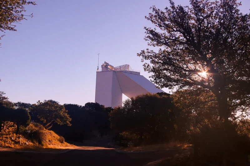 The tall angled tower of the McMath-Pierce Solar Telescope on Kitt Peak against a blue sky