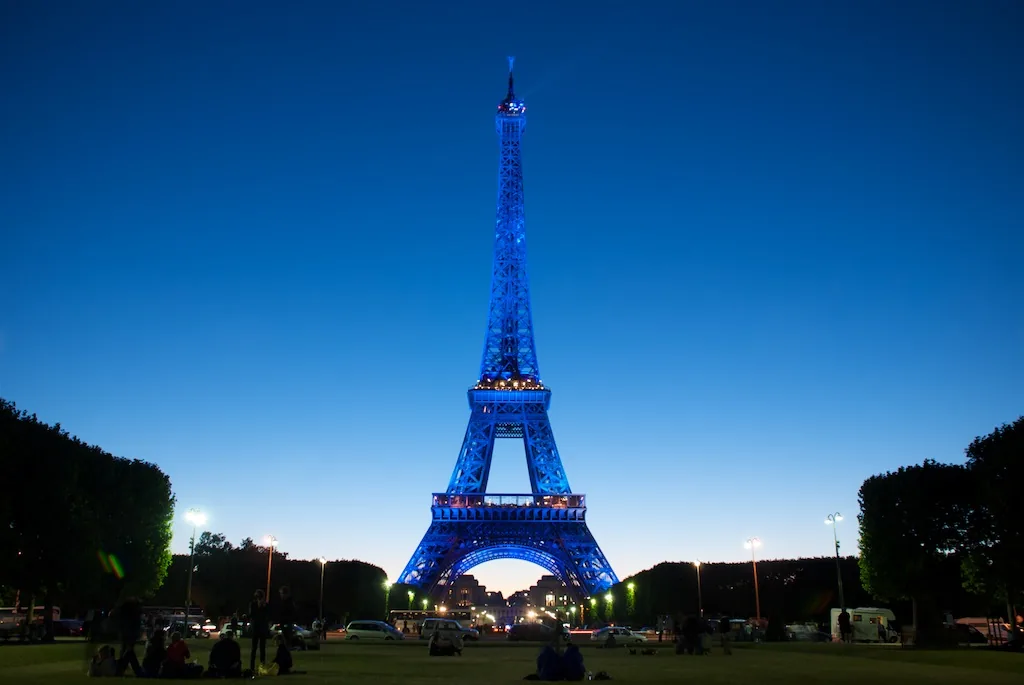 The Eiffel Tower glowing at dusk over the Champ de Mars