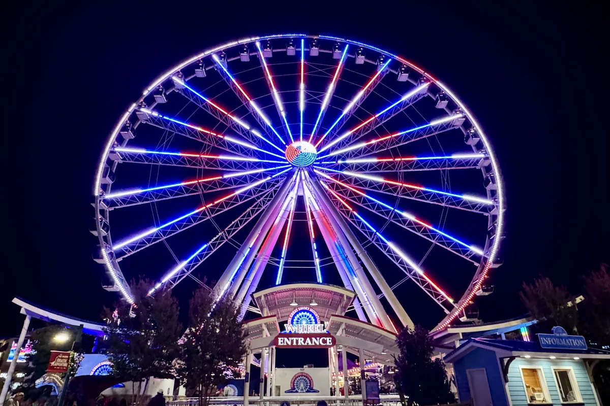 The Great Smoky Mountain Wheel lit in red, white and blue at night at The Island