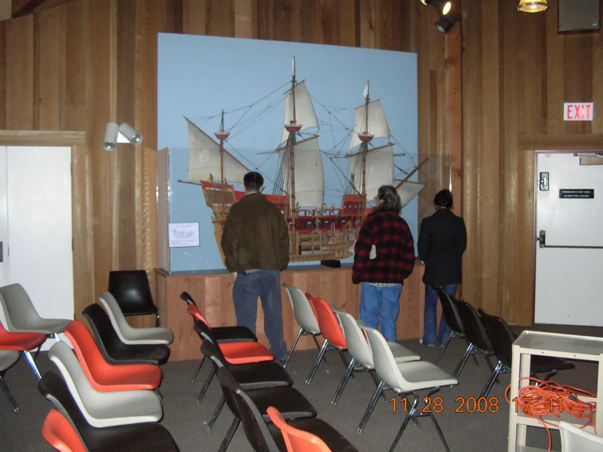 Visitors looking at a large model of a sailing ship inside the Bear Valley Visitor Center