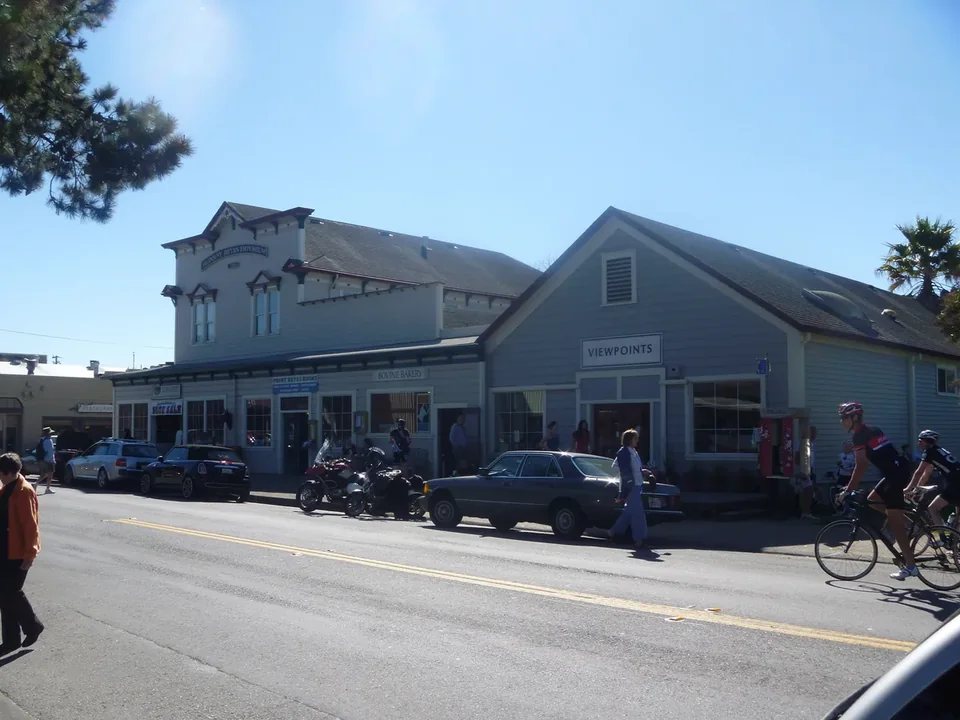 Wooden storefronts along the main street of Point Reyes Station with parked cars and bicycles