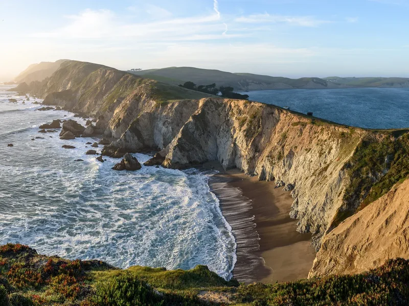 A wide view of tall pale cliffs and beaches from the Chimney Rock Trail