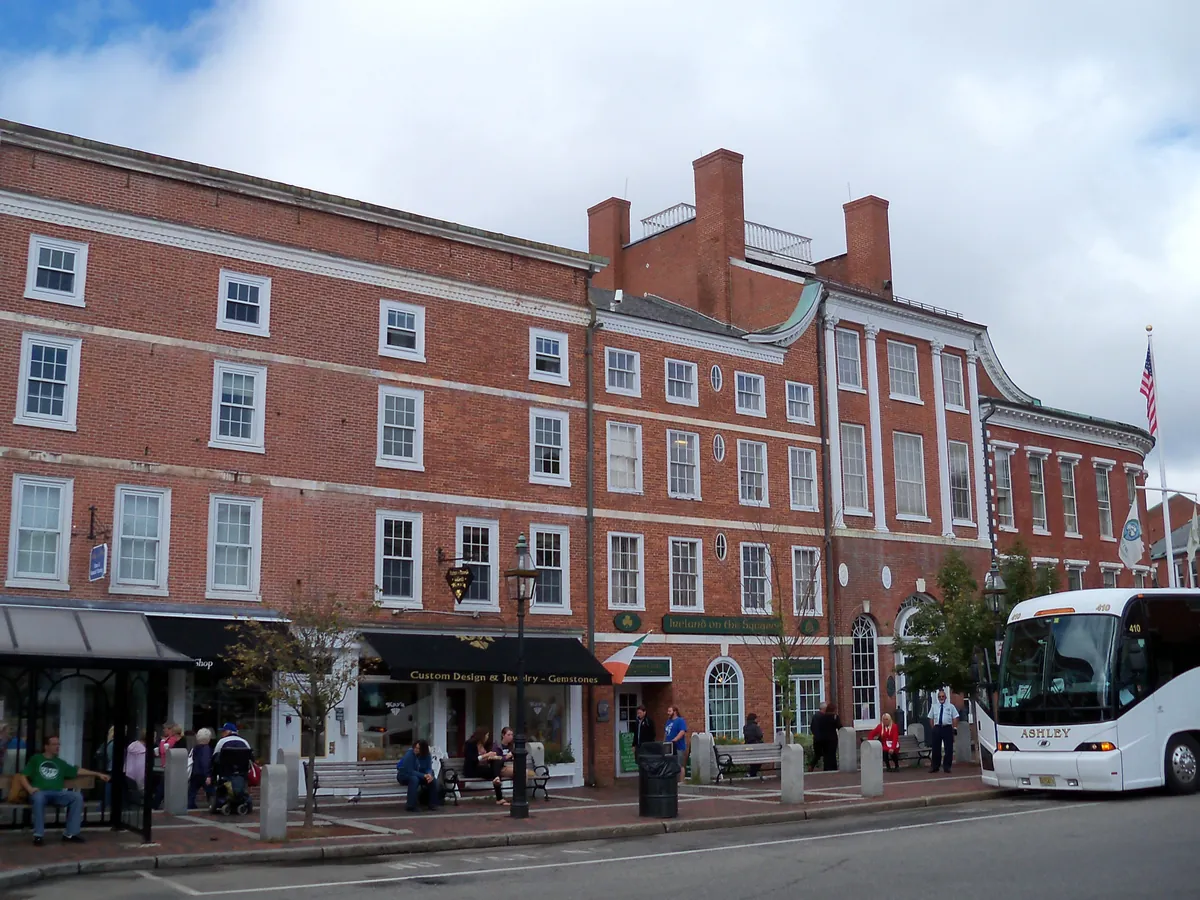 Brick commercial buildings around Market Square in Portsmouth with people on the sidewalk