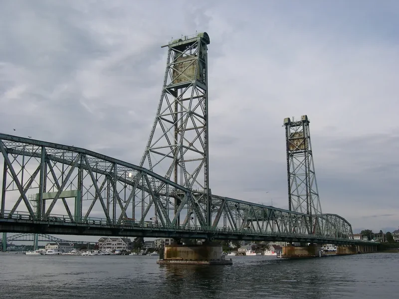 The green steel Memorial Bridge with its two lift towers over the river, seen from Prescott Park