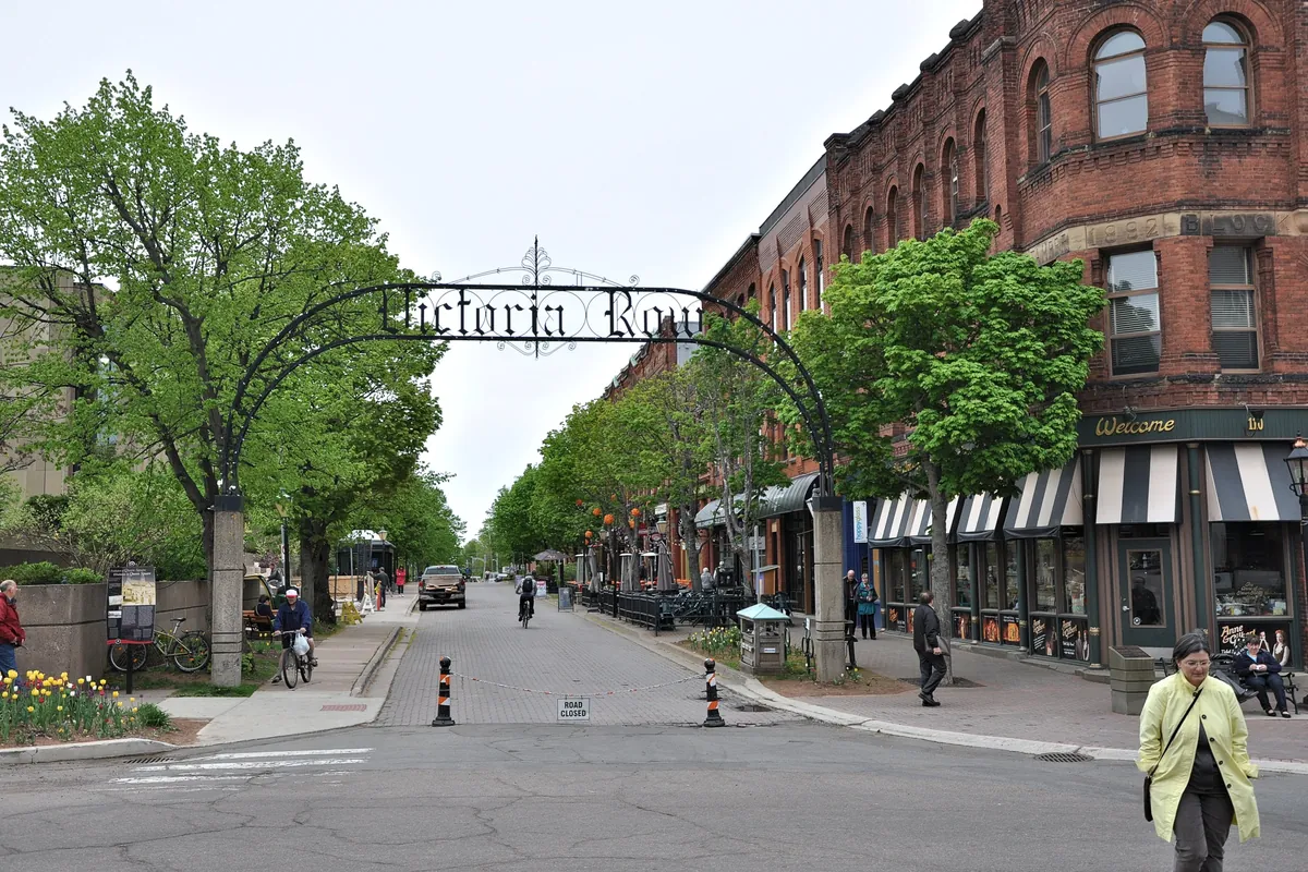 Victoria Row in Charlottetown, a street of red-brick Victorian buildings with trees and an arched street sign