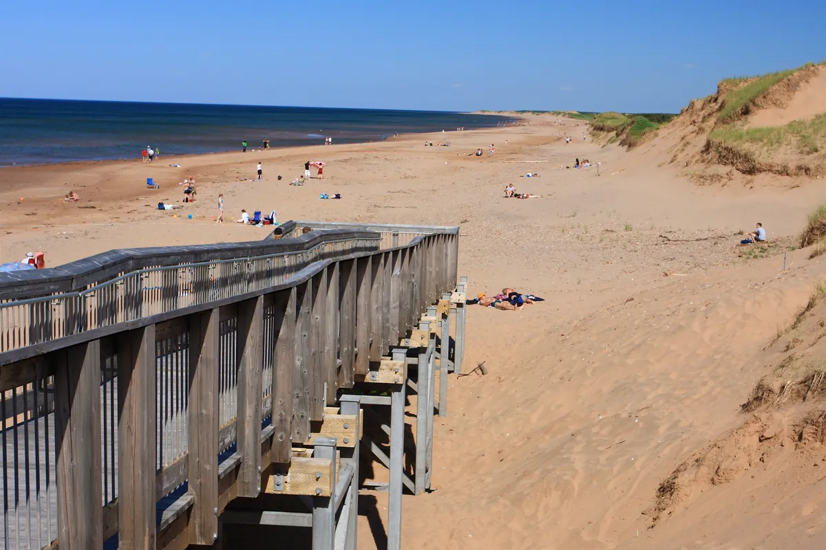 Brackley Beach on Prince Edward Island, a wide sandy beach below a dune with a wooden boardwalk and stairs
