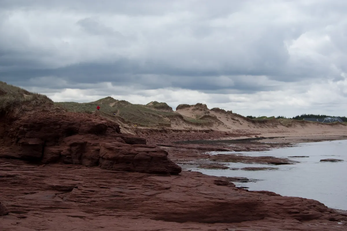 Red sandstone cliffs above a red beach and tide pools at Cavendish on Prince Edward Island
