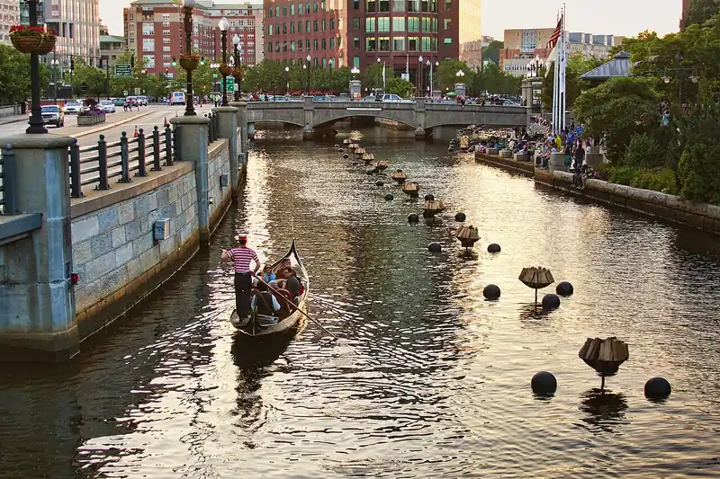 A La Gondola gondola on the Providence River among unlit WaterFire braziers