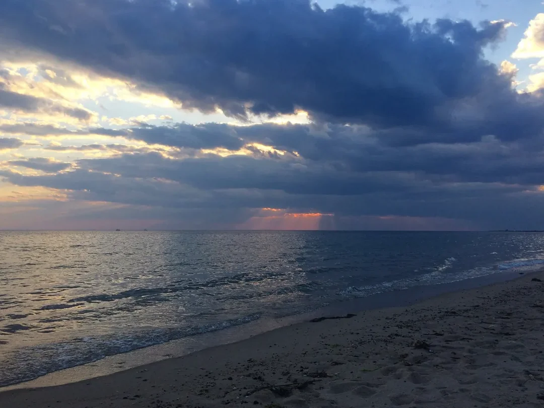 The wide sand of Herring Cove Beach under a bank of cloud at Cape Cod National Seashore