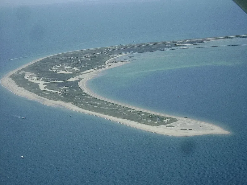 An aerial view of the thin curve of Long Point sand spit closing Provincetown Harbor