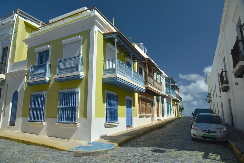 A green and blue corner house on a cobbled street in Old San Juan