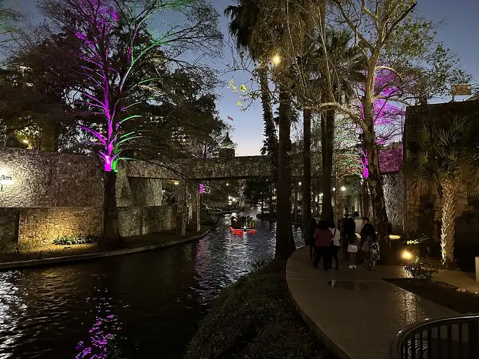 San Antonio River Walk at night with colorful lights reflecting on the water
