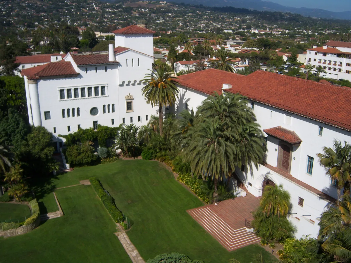 The white Santa Barbara County Courthouse with arches and its tower above a green lawn