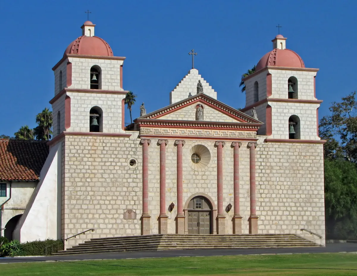The twin-towered facade of Old Mission Santa Barbara under a blue sky