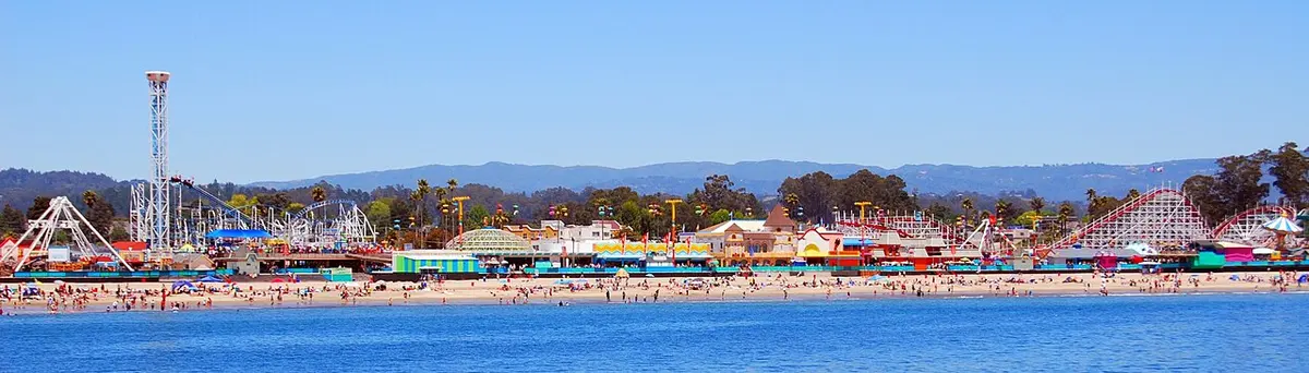 The Santa Cruz Beach Boardwalk rides along Main Beach on a summer day