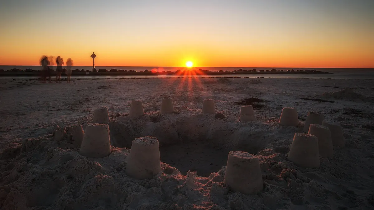 A sandcastle glowing at sunset on a Florida Gulf beach