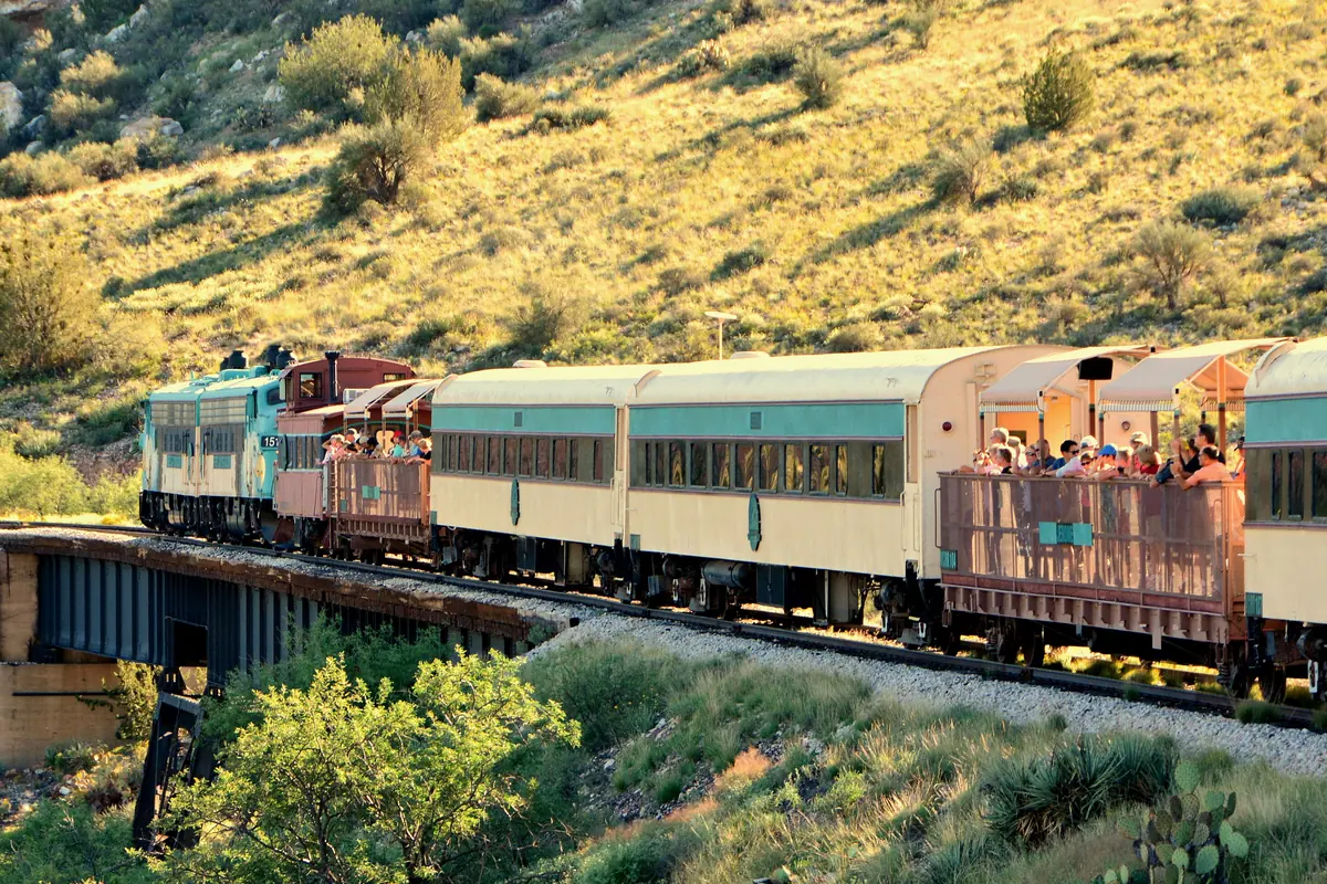 The Verde Canyon Railroad train with open-air cars rolling through the canyon near Clarkdale