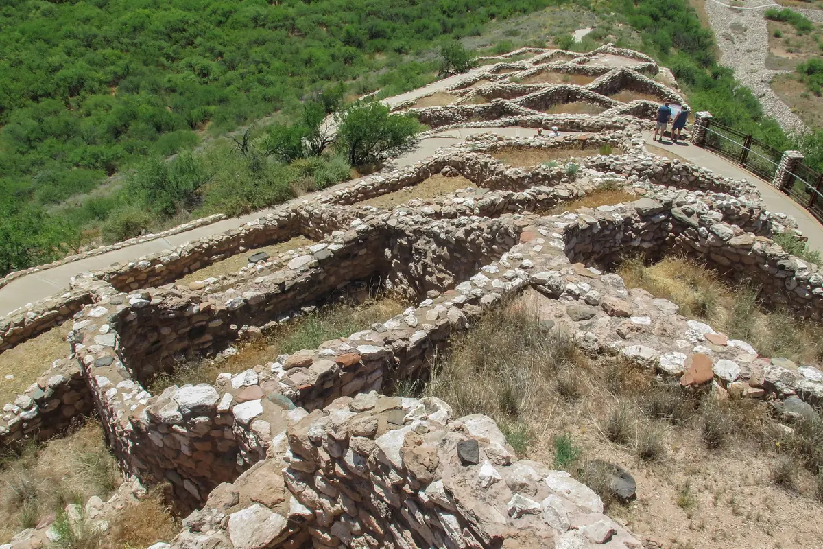 Stone walls of the Tuzigoot pueblo ruins on a ridge above the green Verde Valley