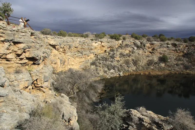 Montezuma Well, a round spring-fed pool in a limestone sinkhole under a cloudy winter sky