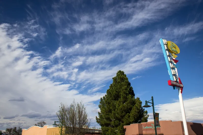 A vintage neon sign on Main Street in Old Town Cottonwood, Arizona, under a blue sky