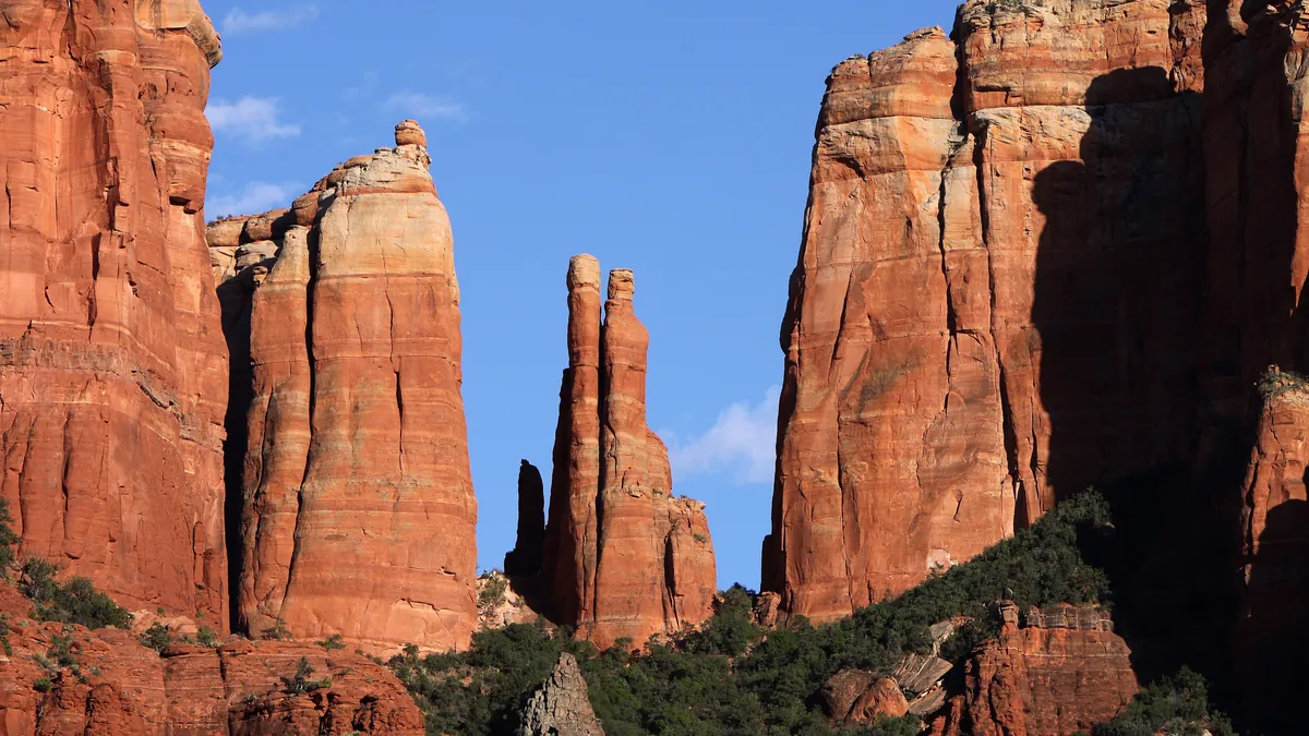 Cathedral Rock, a tall red sandstone butte, above juniper scrub in Sedona