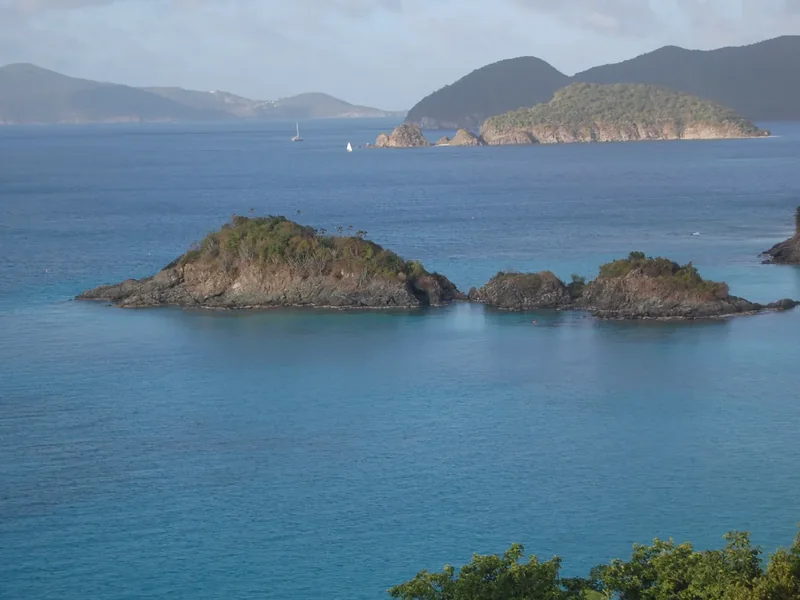 Trunk Bay with its small cay in turquoise water and green islands on the horizon