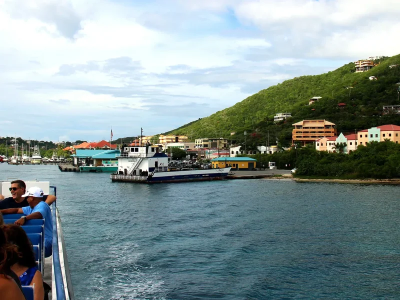 Passengers on the upper deck of the ferry from Red Hook approaching Cruz Bay, with the town on the green hillside