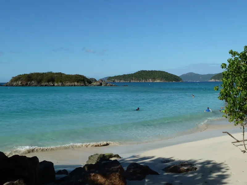 Cinnamon Cay and Whistling Cay offshore from Cinnamon Bay, calm turquoise water and a rocky shore